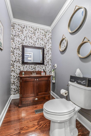 Bathroom featuring ornamental molding, toilet, wood-type flooring, and vanity
