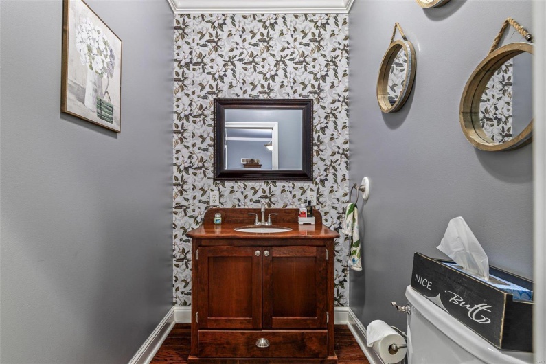 Details with hardwood / wood-style flooring, vanity, and toilet