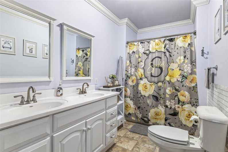 Bathroom featuring vanity, curtained shower, ornamental molding, and toilet