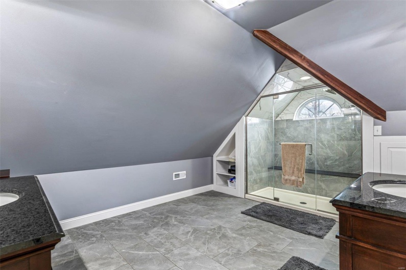 Bathroom with vanity, built in shelves, lofted ceiling, and a shower with shower door