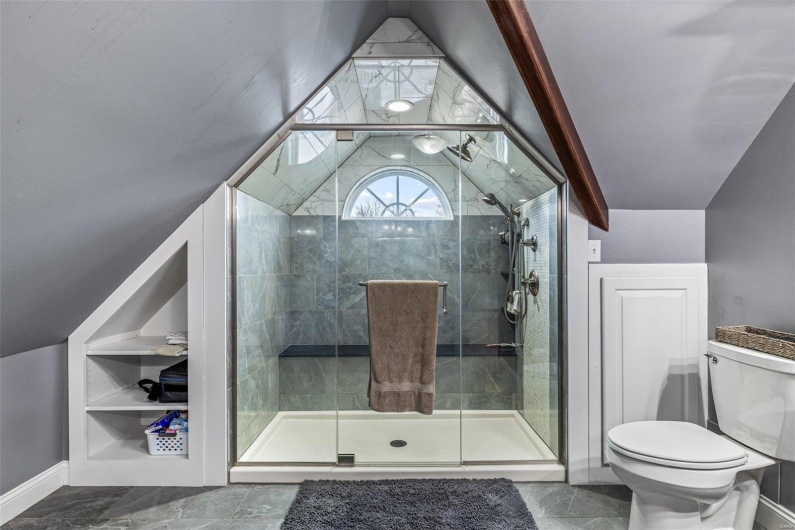 Bathroom with lofted ceiling, toilet, and an enclosed shower