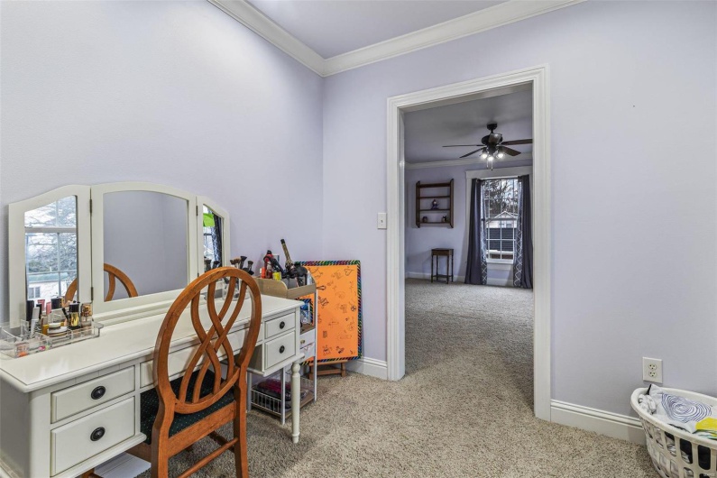 Carpeted office with ornamental molding, a healthy amount of sunlight, and ceiling fan