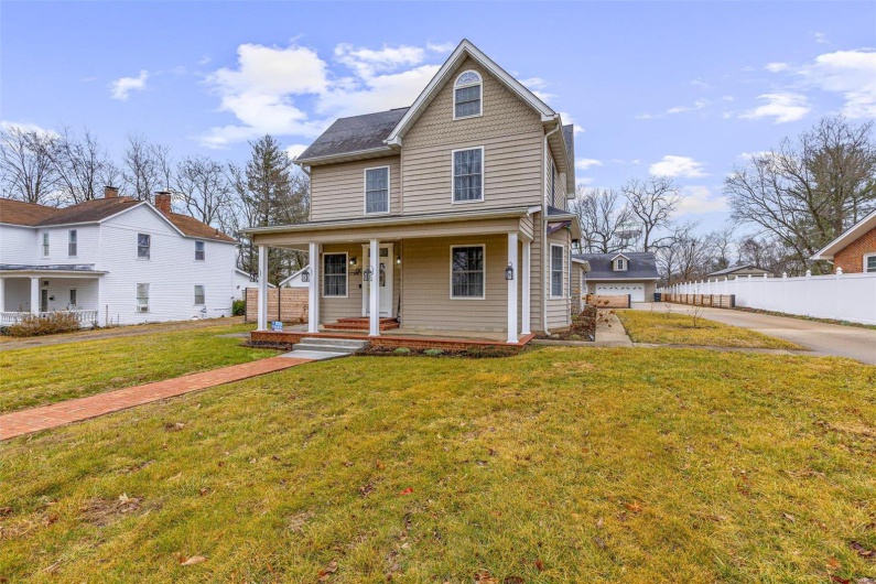 View of front of property featuring covered porch and a front lawn