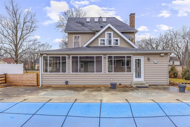 Rear view of property with a covered pool and a patio area