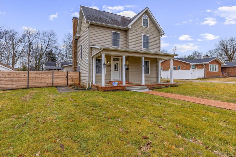 View of front facade with a porch and a front lawn