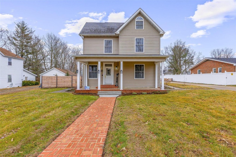 View of front of house with a front yard and covered porch