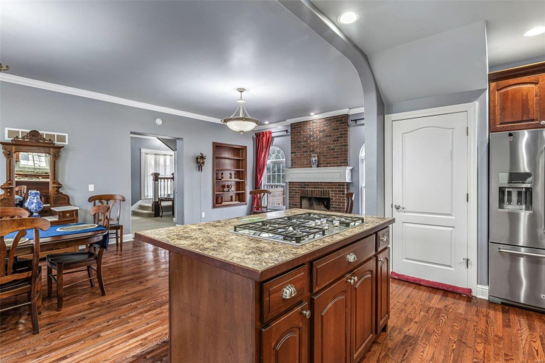Kitchen with a kitchen island, appliances with stainless steel finishes, dark hardwood / wood-style floors, and pendant lighting