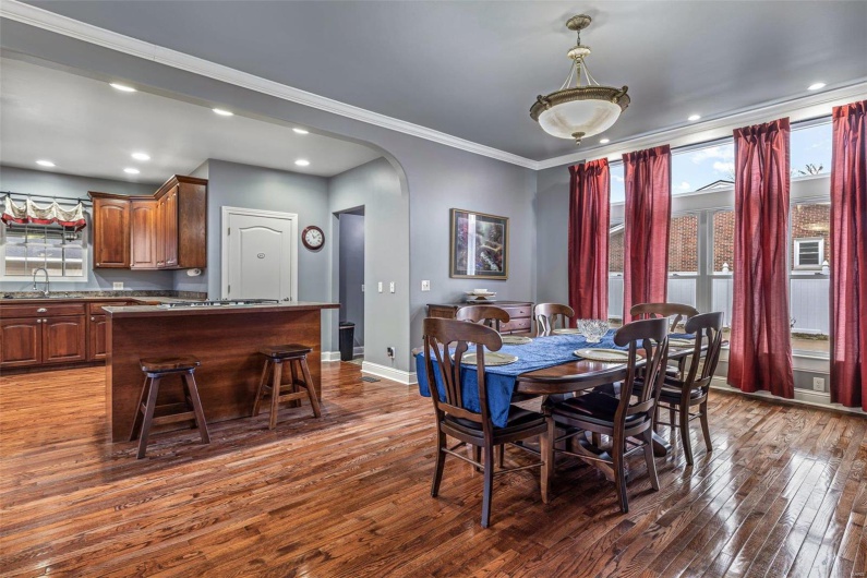 Dining room with crown molding, dark hardwood / wood-style flooring, and sink