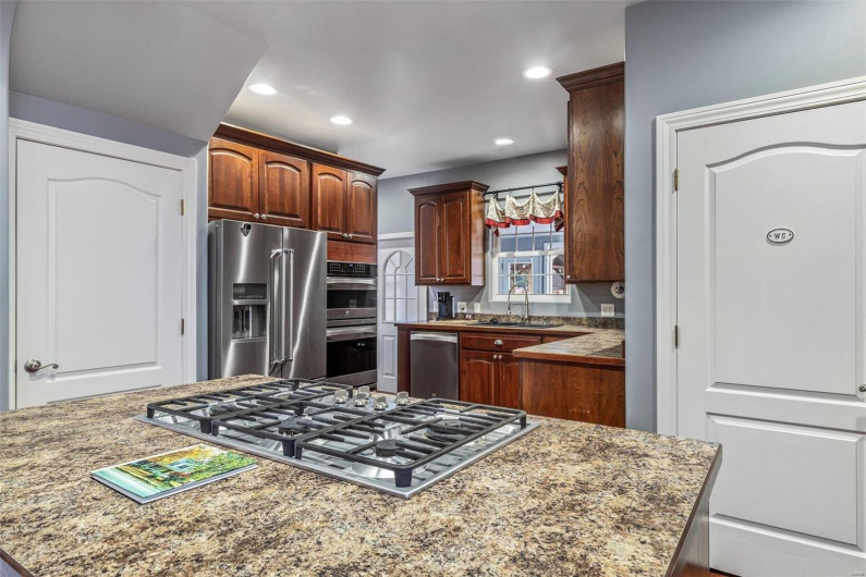 Kitchen with sink, stainless steel appliances, a center island, and stone counters