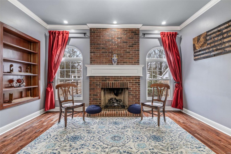 Sitting room with hardwood / wood-style floors, a fireplace, and ornamental molding
