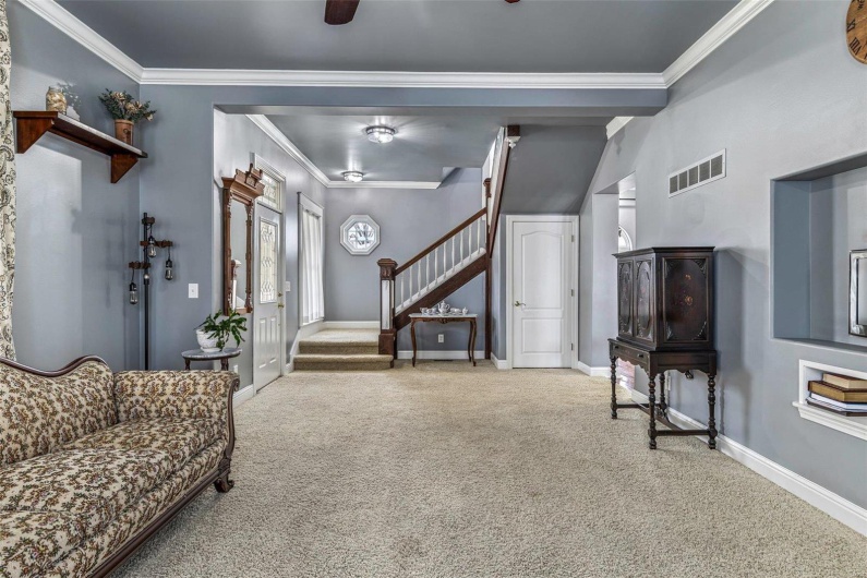 Carpeted living room with crown molding