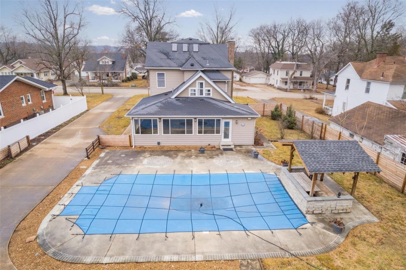 Rear view of property with a patio and a covered pool