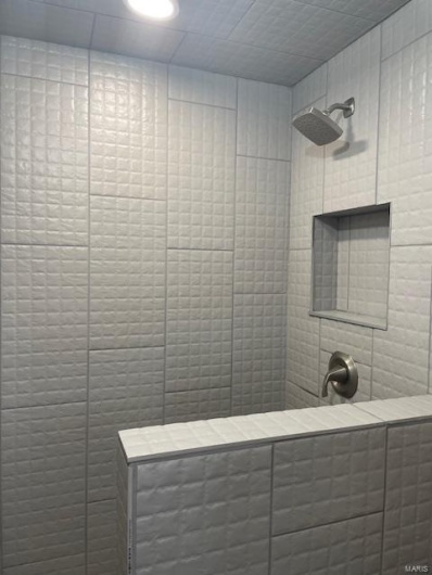 Bathroom with tile patterned flooring and a shower