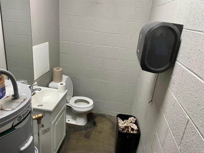 Bathroom with vanity, concrete flooring, and toilet