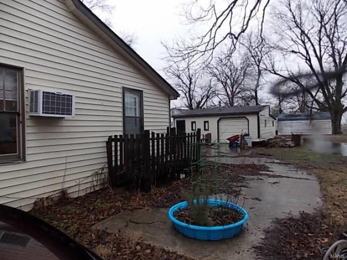 View of side of home featuring a garage and an outdoor structure