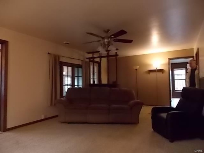 Unfurnished living room featuring light colored carpet and ceiling fan