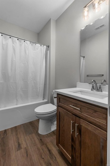 Full bathroom featuring toilet, vanity, shower / tub combo, and wood-type flooring