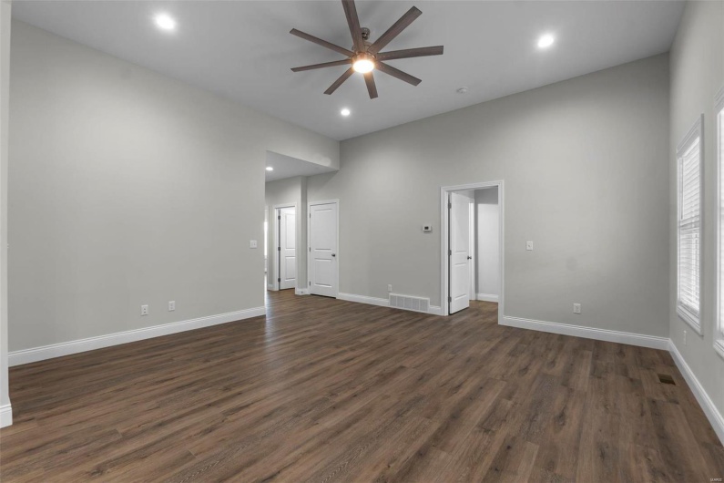 Spare room featuring plenty of natural light, dark hardwood / wood-style flooring, and ceiling fan
