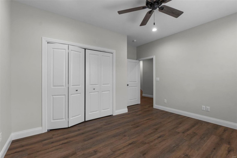 Unfurnished bedroom featuring ceiling fan, a closet, and dark hardwood / wood-style flooring