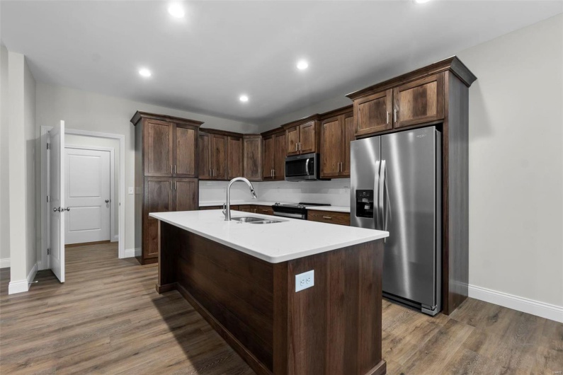 Kitchen with dark brown cabinetry, an island with sink, stainless steel appliances, and sink