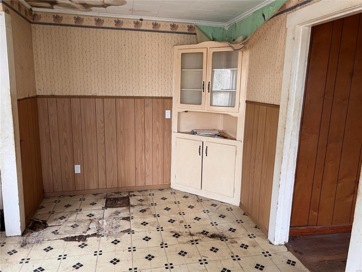 Bathroom featuring crown molding and wood walls
