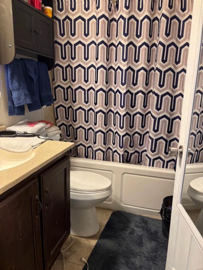 Full bathroom featuring vanity, tile patterned floors, shower / bath combination with curtain, and toilet
