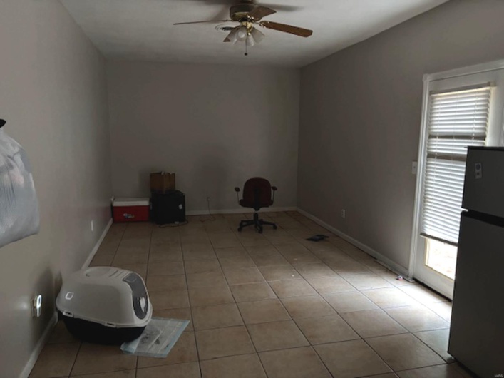 Tiled spare room featuring ceiling fan