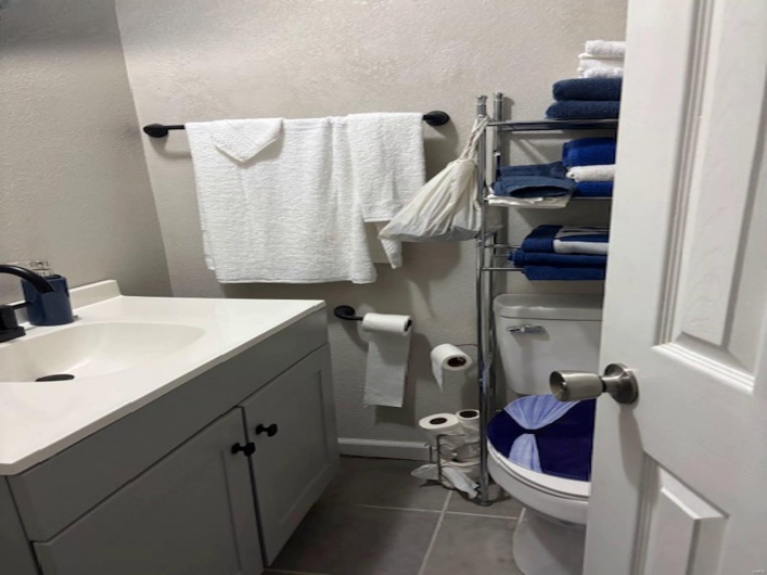 Bathroom with vanity, toilet, and tile patterned flooring