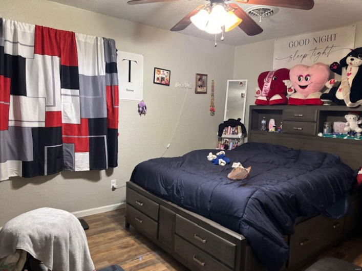 Bedroom with dark wood-type flooring and ceiling fan