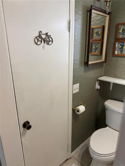 Bathroom with tile walls, tile patterned floors, and toilet