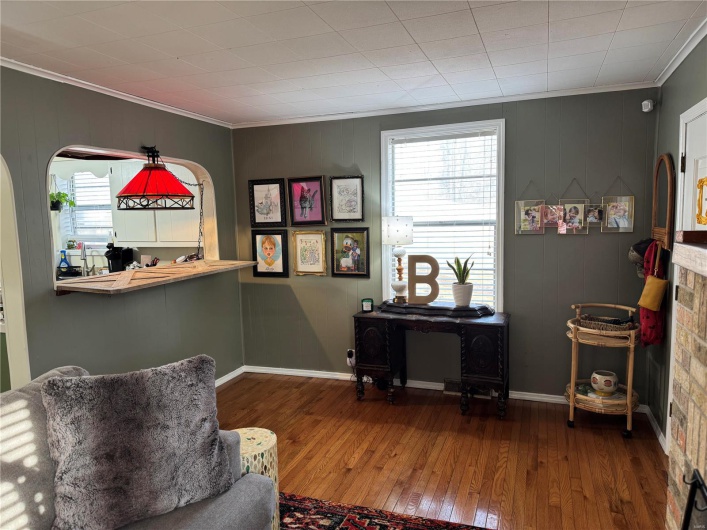Living area featuring hardwood / wood-style flooring, ornamental molding, and a healthy amount of sunlight