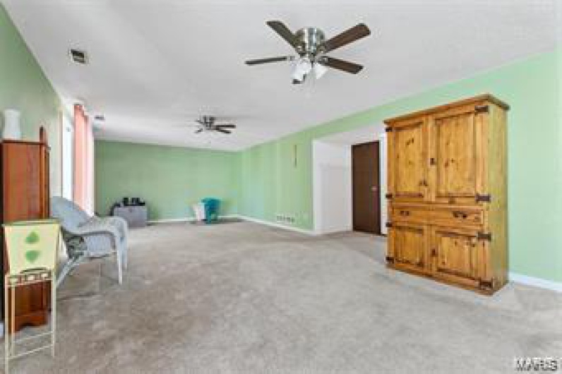 Sitting room featuring ceiling fan and light carpet