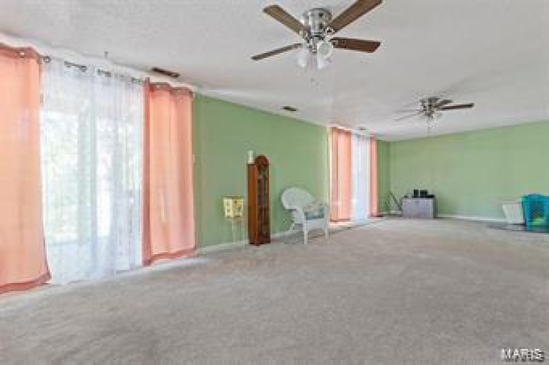 Carpeted spare room featuring ceiling fan
