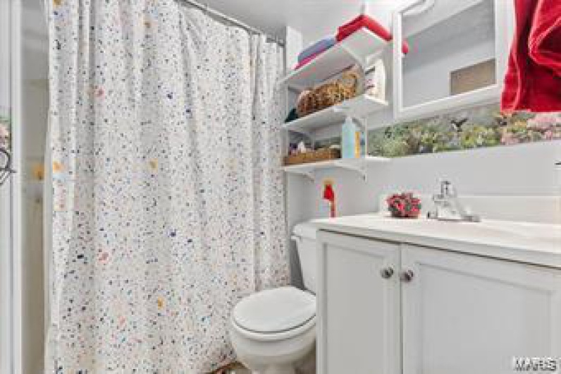 Bathroom with vanity, curtained shower, and toilet