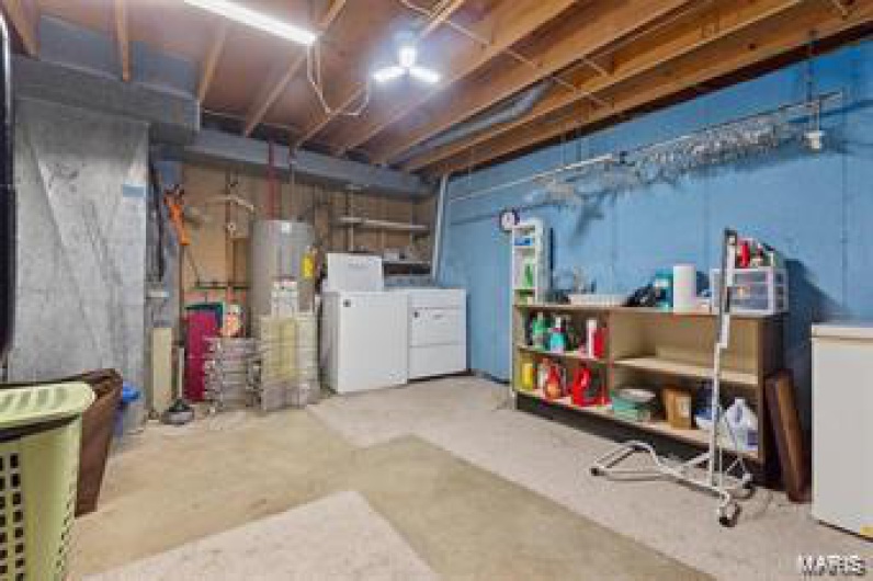 Basement featuring water heater and washing machine and clothes dryer