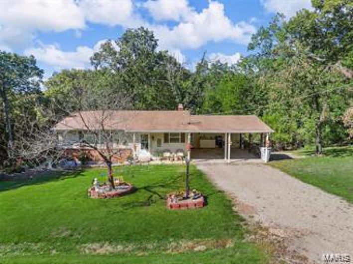 Single story home featuring a carport and a front lawn