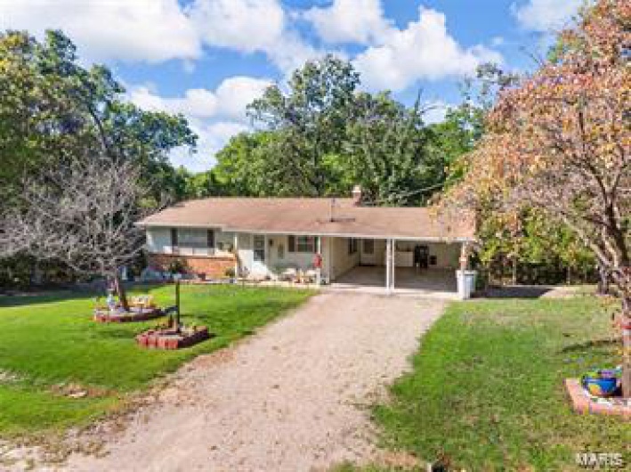 Single story home featuring a carport and a front lawn