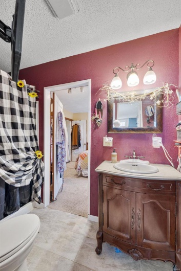 Bathroom with vanity, a textured ceiling, and toilet