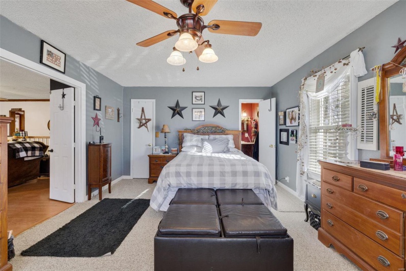 Bedroom featuring ceiling fan, light colored carpet, and a textured ceiling