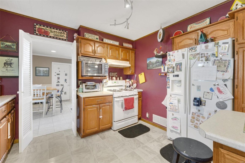 Kitchen with crown molding, track lighting, and white appliances