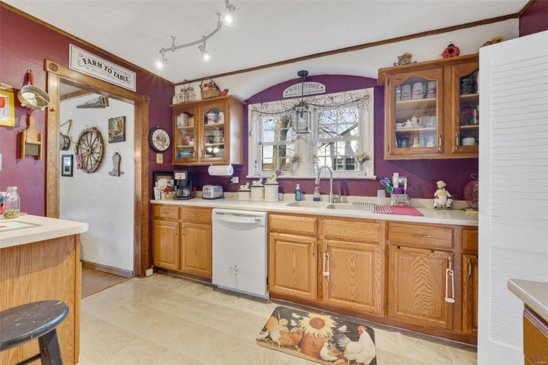 Kitchen featuring dishwasher, sink, and hanging light fixtures