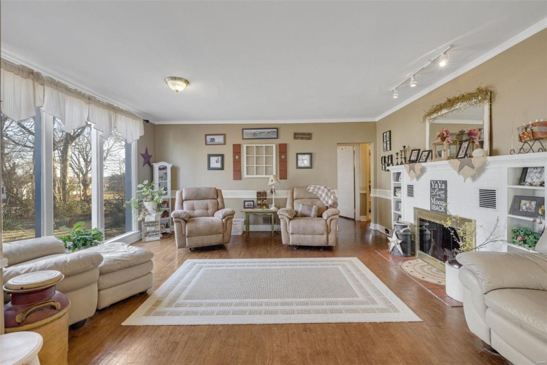 Living room featuring hardwood / wood-style flooring, ornamental molding, and rail lighting