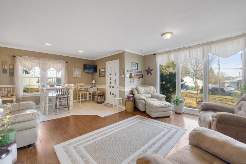 Living room with crown molding and light hardwood / wood-style floors