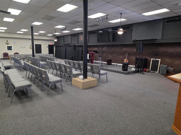 Miscellaneous room featuring a drop ceiling, carpet floors, and a ceiling fan