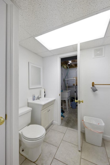 Bathroom with vanity, walk in shower, toilet, and a drop ceiling