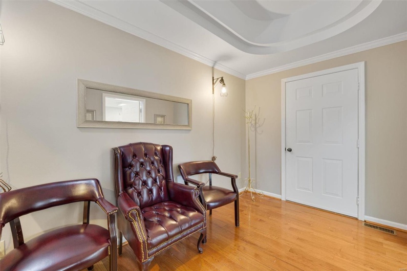 Sitting room featuring crown molding, wood-type flooring, and a raised ceiling