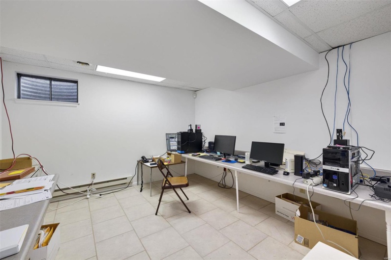 Tiled home office with a baseboard heating unit and a paneled ceiling