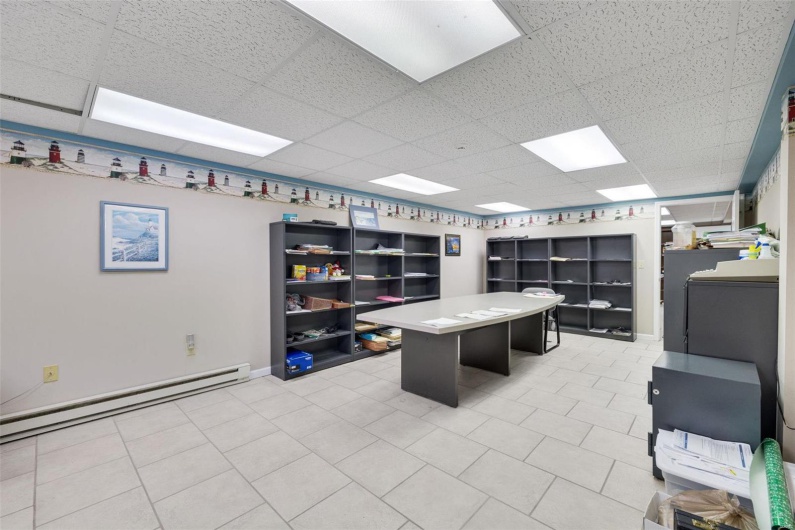 Office space featuring a drop ceiling, a baseboard radiator, and tile patterned floors