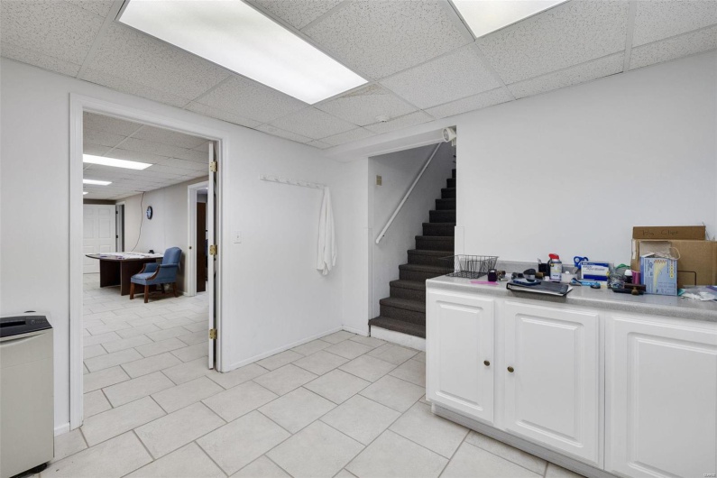 Basement with light tile patterned floors and a drop ceiling