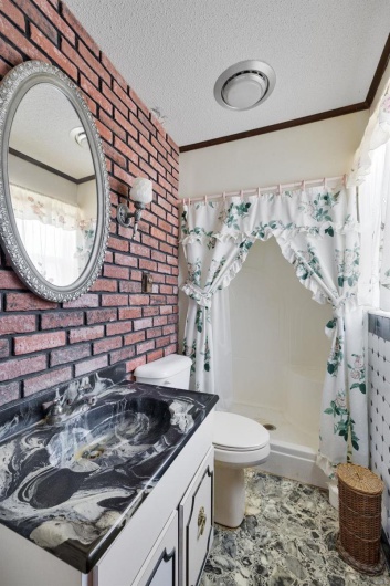 Bathroom with vanity, curtained shower, toilet, and a textured ceiling